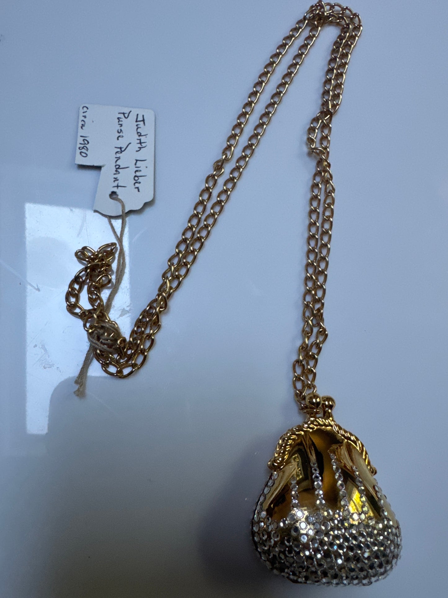 adorable 1980s must have pendant necklace by Judith Lieber. This collectible purse on a chain that opens is decorated with rhinestones.