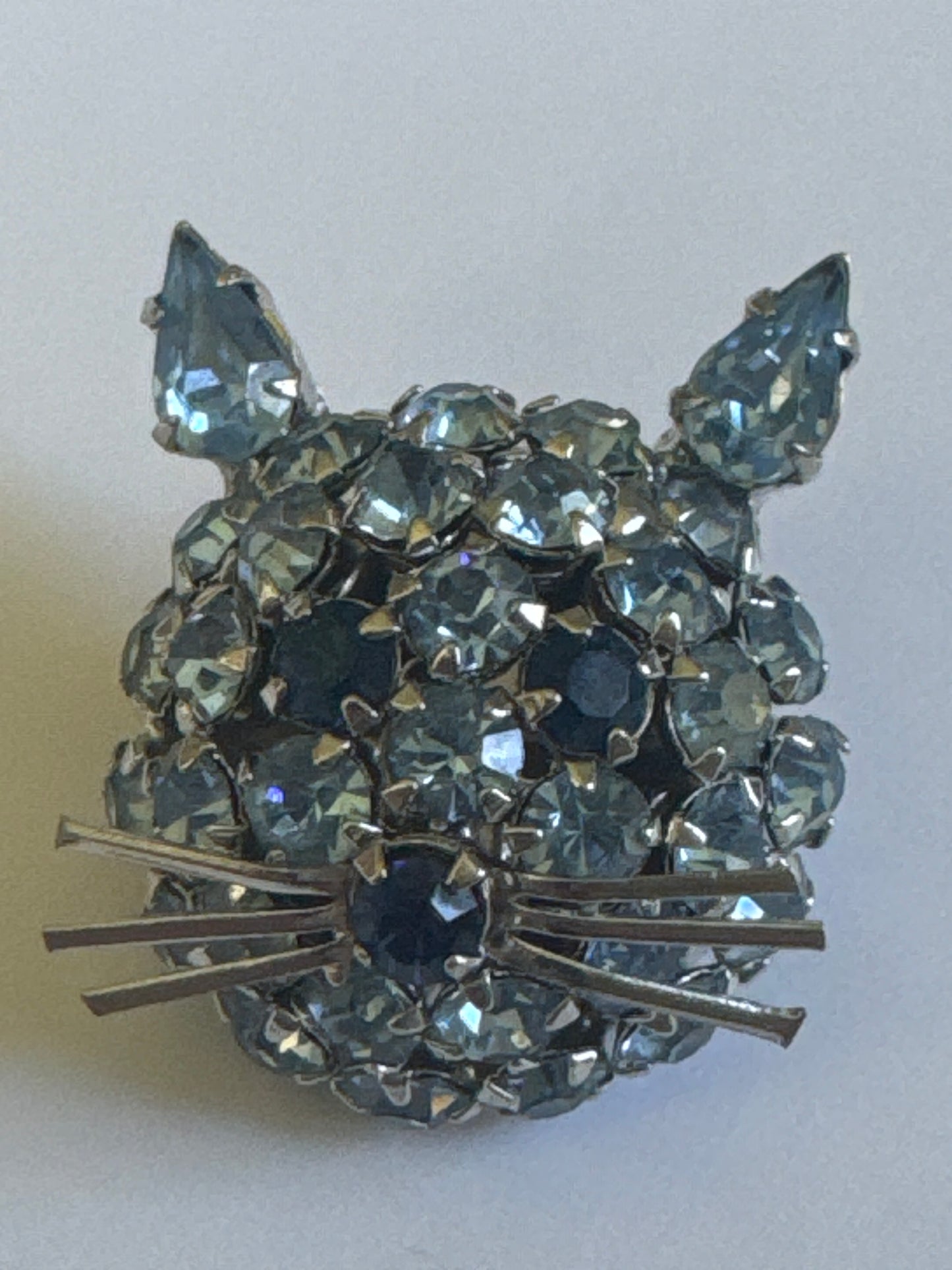 1950s signed WARNER mini kitty cat brooch featuring shades of blue rhinestones