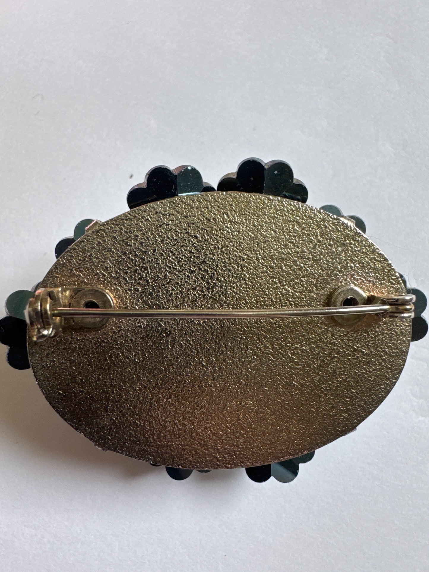 A striking vintage brooch composed of layered, faceted crystal florets in rich shades of teal, emerald, and deep ocean blue. Each petal-like stone is cut to catch the light from every angle, creating a dimensional, almost floral cluster effect that feels