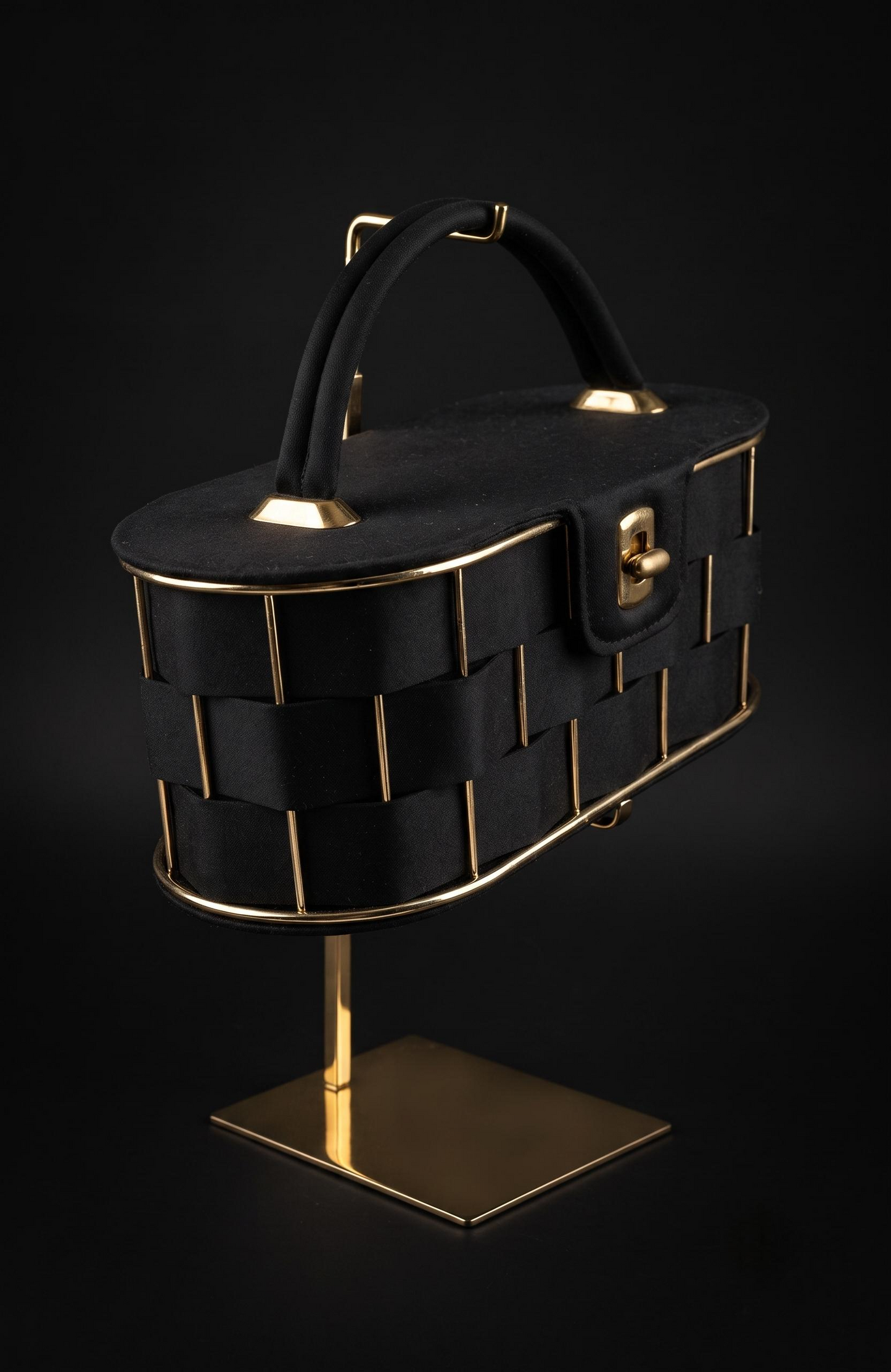 It is a 1940s black suede box Bag with woven suede and gold tone detailing