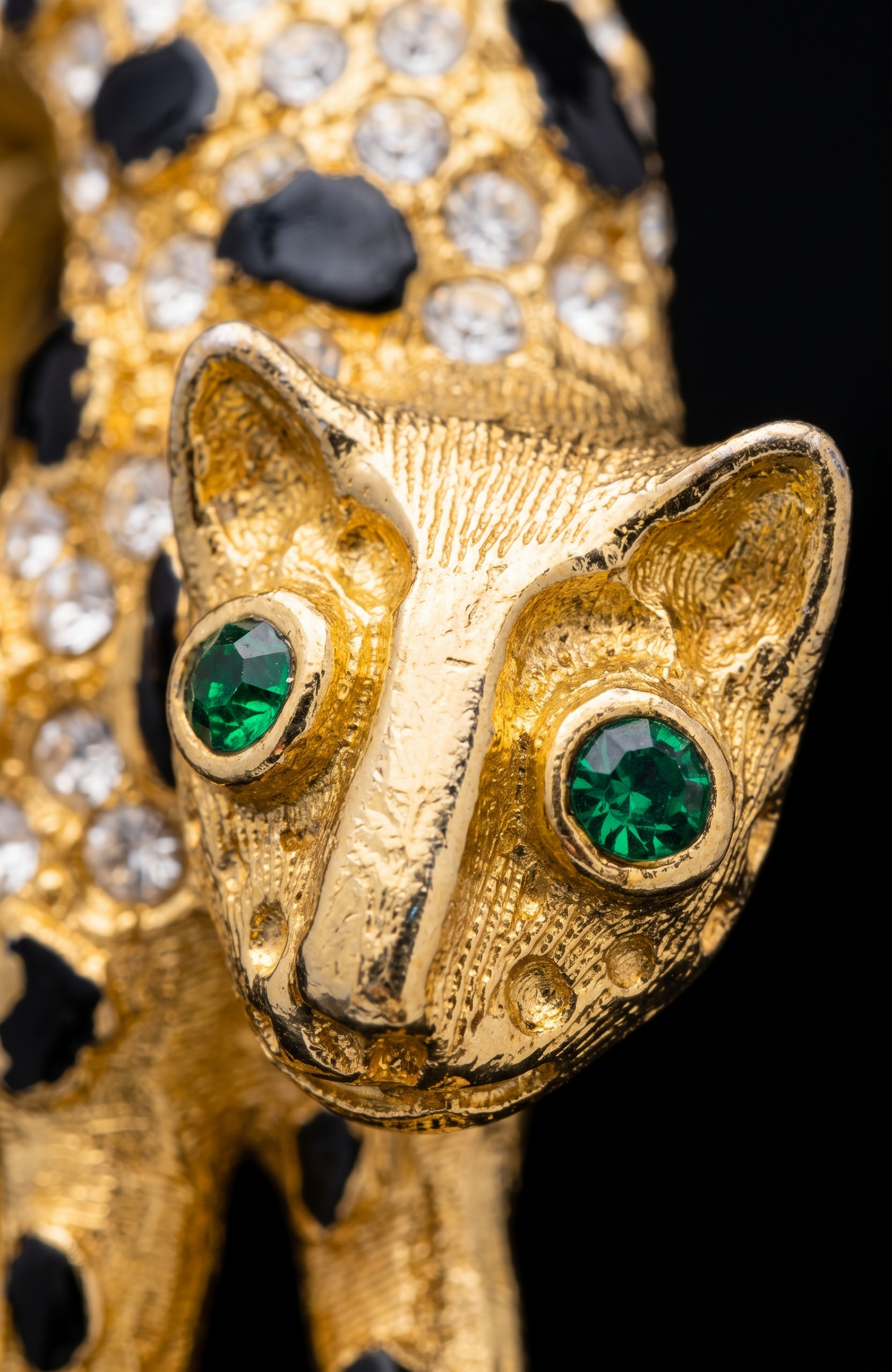 1960s panther brooch with clear, crystal rhinestones and emerald colored eyes. Black enamel spots ~ some need a little touchup, or not.