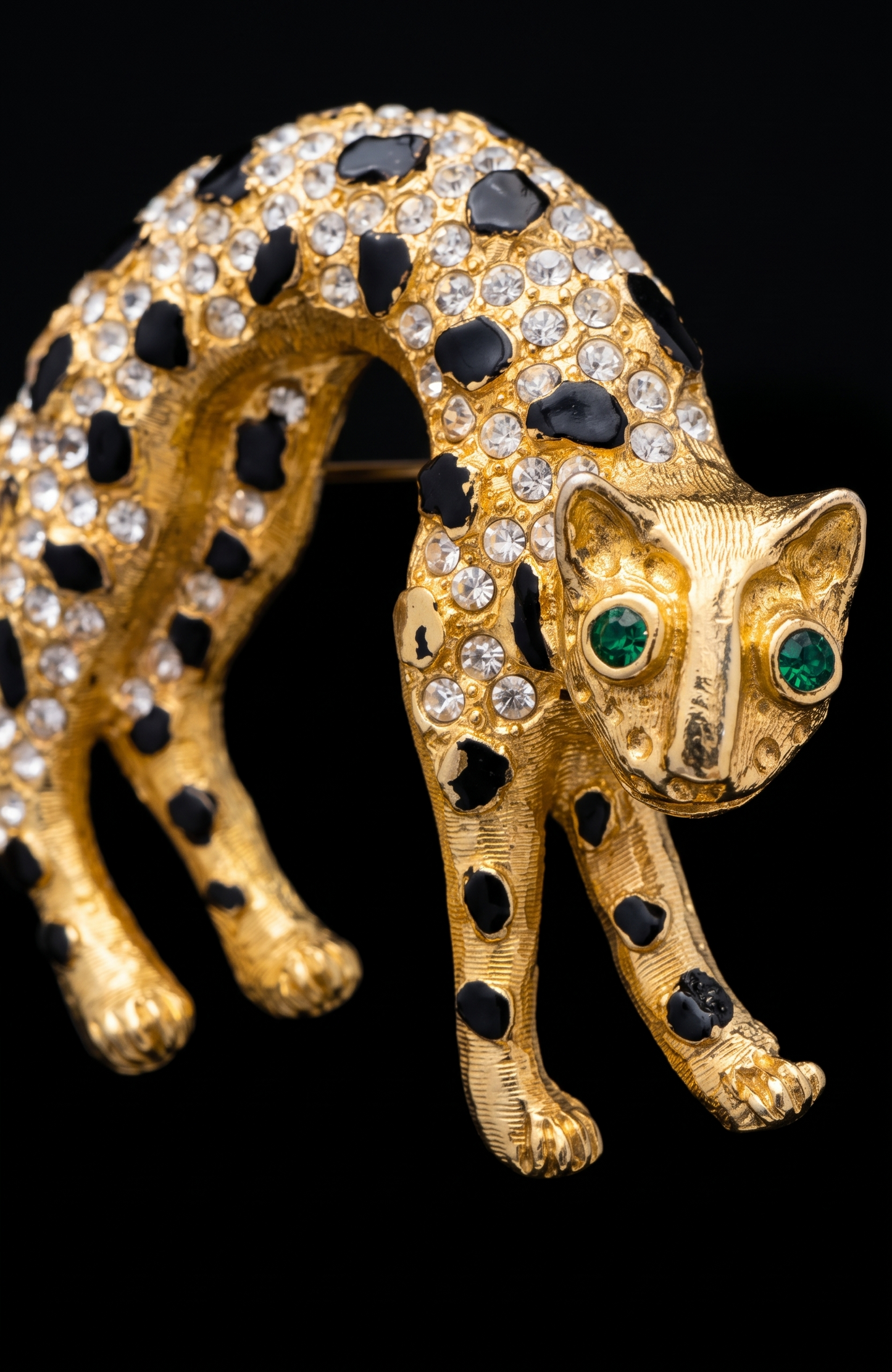 1960s panther brooch with clear, crystal rhinestones and emerald colored eyes. Black enamel spots ~ some need a little touchup, or not.