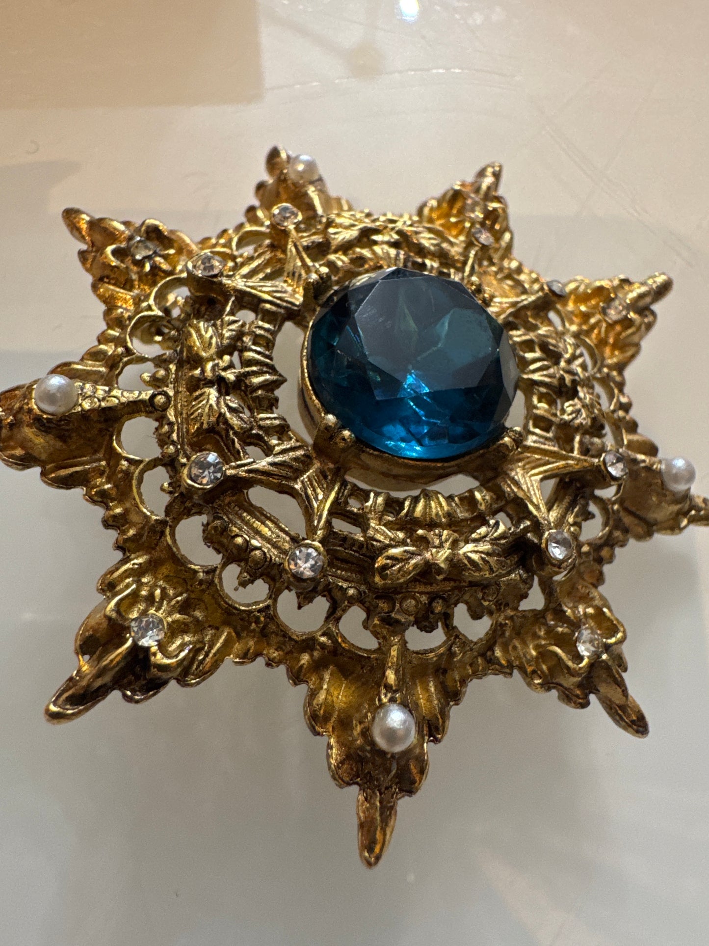 Beautiful gold tone, 1950s brooch with rhinestone pearls and blue Centerstone
