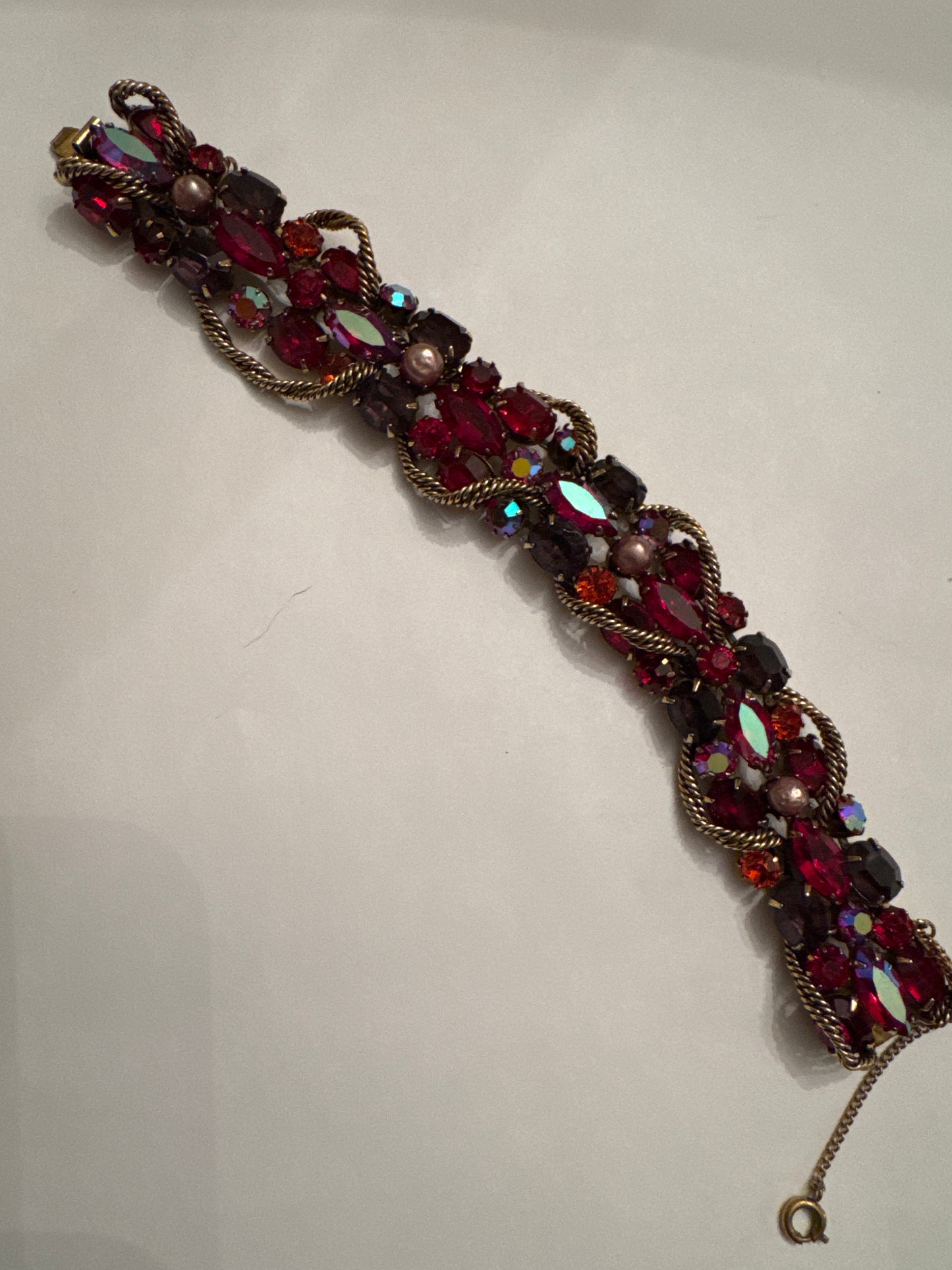 1950s signed KRAMER of NY rhinestone bracelet featuring red crystals and aurora borealis with a gold link chain throughout ￼