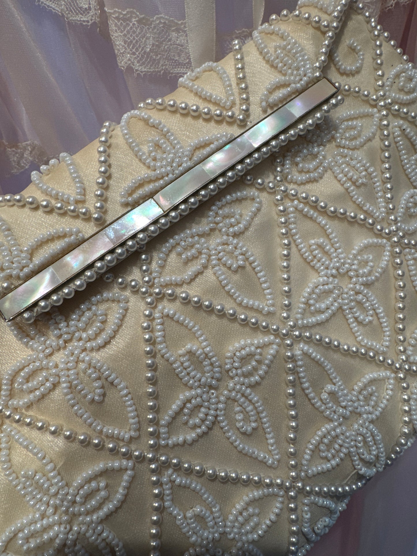 1940s beaded clutch with mother of pearl detail and pearl beading. Note back