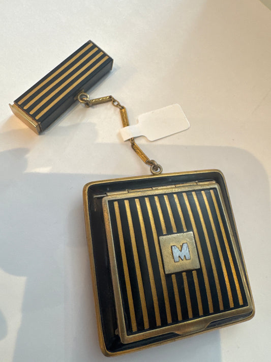 1920s Makeup compact in gold and black enamel with the letter M. Has blush powder mirror, and lipstick.