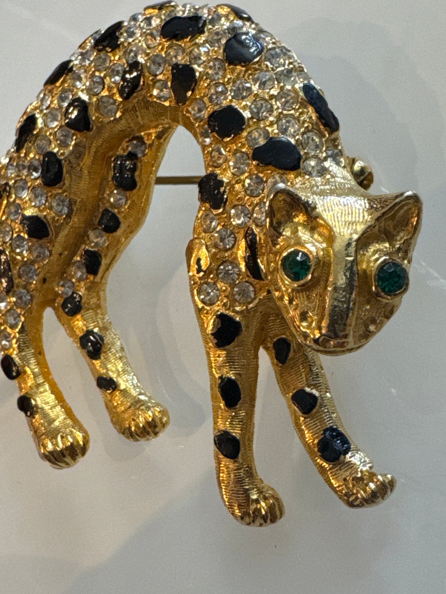 1960s panther brooch with clear, crystal rhinestones and emerald colored eyes. Black enamel spots ~ some need a little touchup, or not.