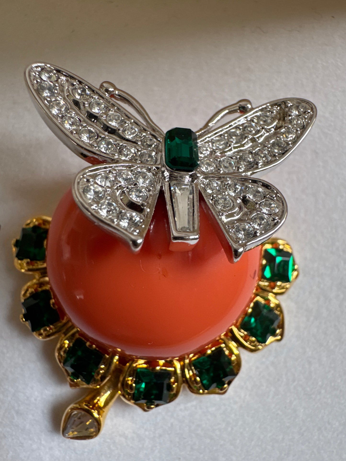A boxed Kenneth Jay Lane ‘Treasures of the Duchess’ brooch, originally sold through QVC—featuring a coral-tone cabochon, emerald rhinestones & a whimsical dragonfly detail. Made by KJL after a piece from his friend, The Duchess of Windsor's own collection
