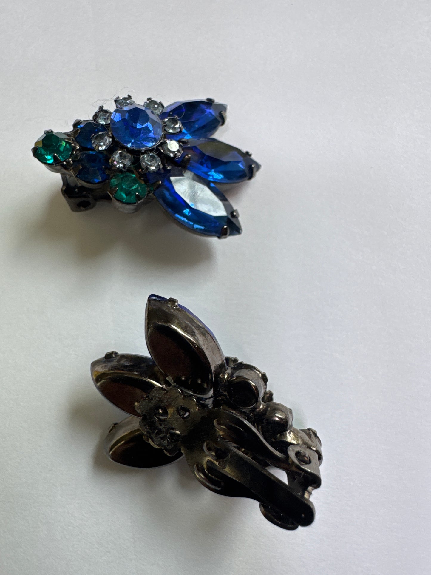 Gorgeous clip on teal and blue sapphire colored rhinestone earrings. Matching brooch sold separate separately.