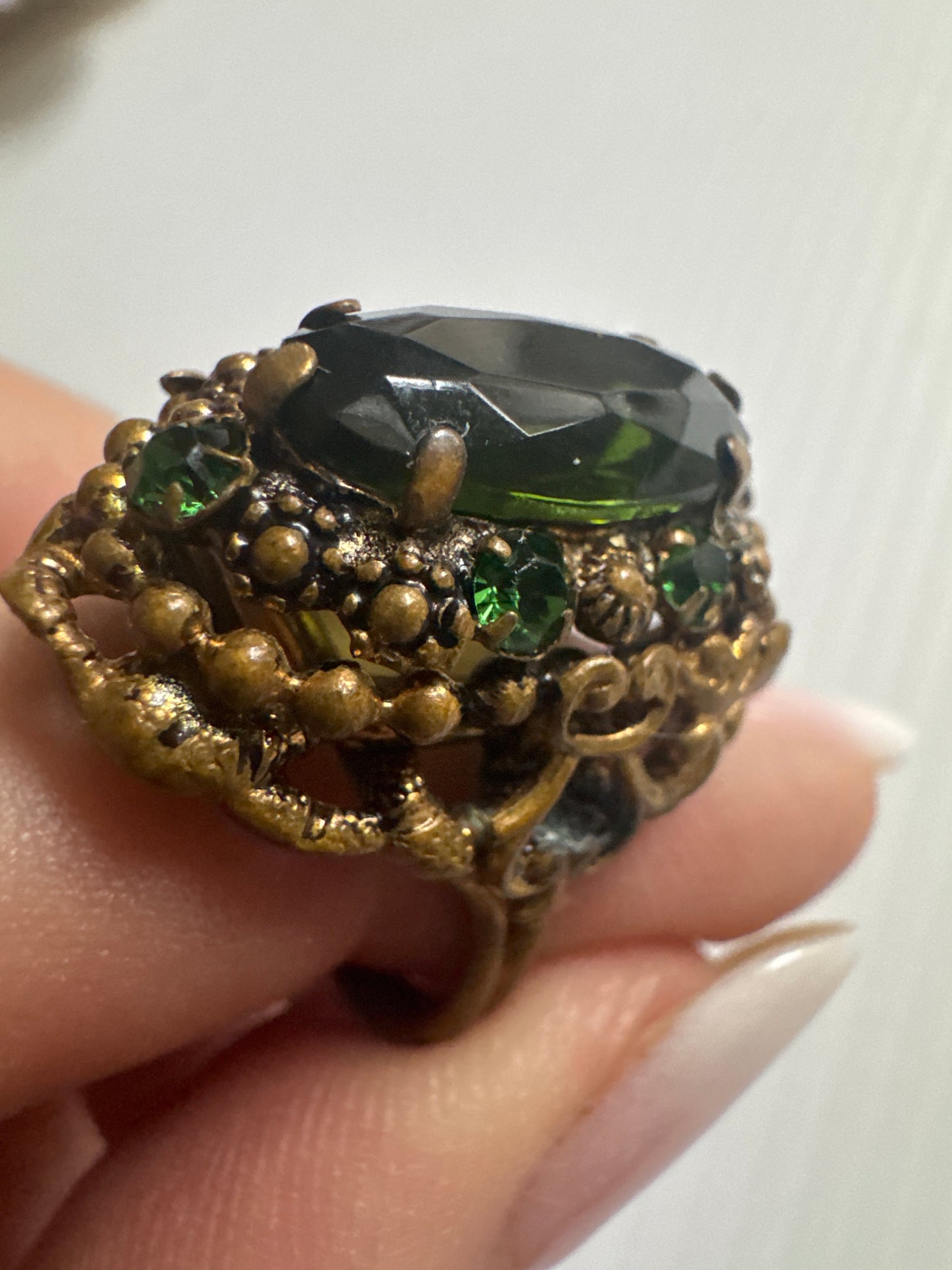 fabulous 1940s Czech glass ring with filigree detail, large green center stone and small green stones in setting