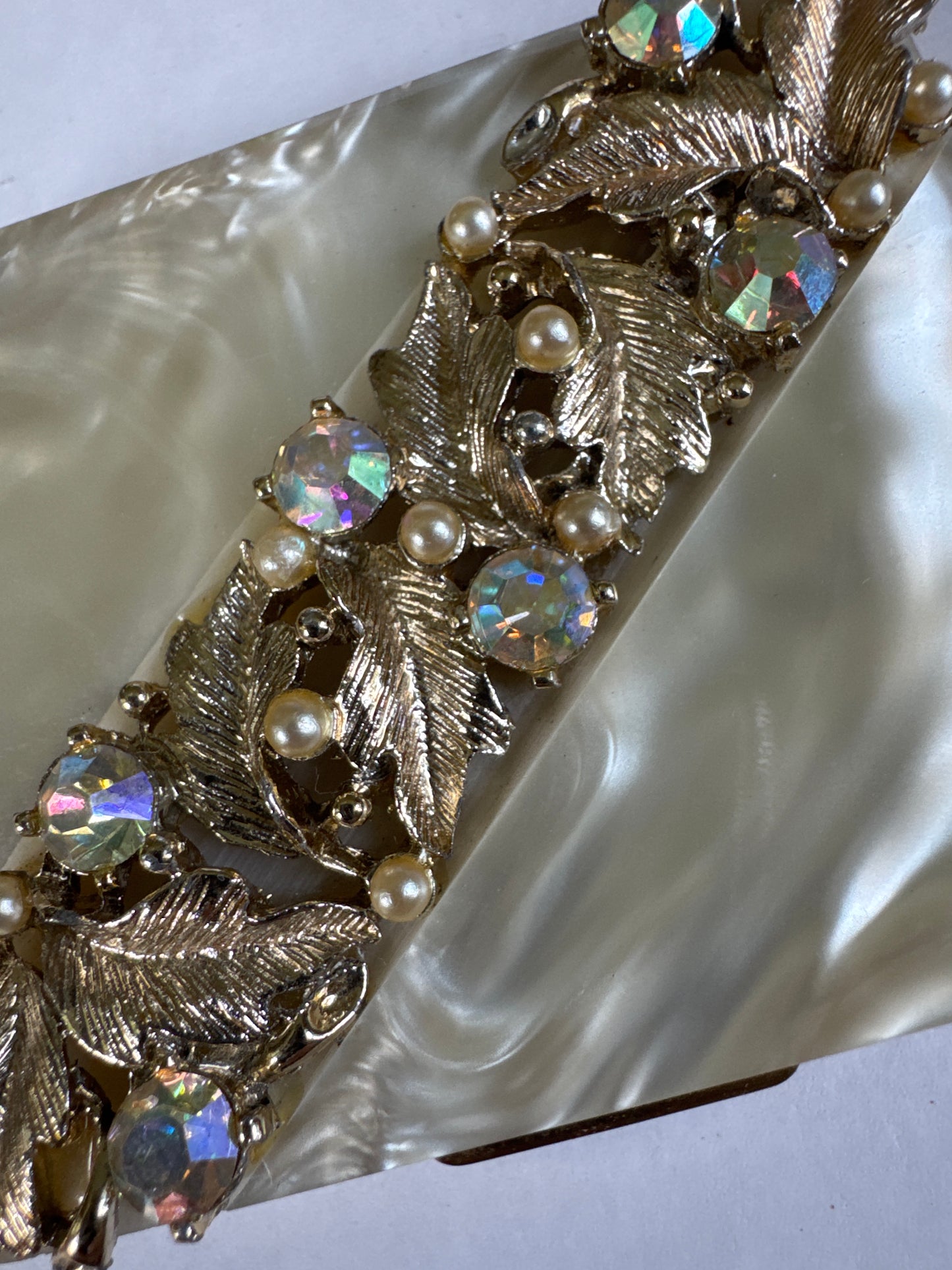 Beautiful 1940s mother-of-pearl Makeup compact with gold tone, leaf design aurora borealis stones and pearls signed S.F. Co 5th Avenue