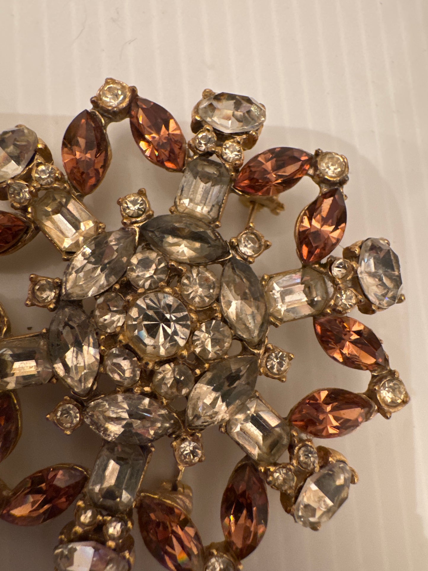 Unsigned brooch attributed to Schreiner New York, circa late 1950s. Identified by its unfoiled stones (creating a glow instead of a sparkle) dramatic mixed cuts, sculptural gold-tone casting, and signature dimensional construction