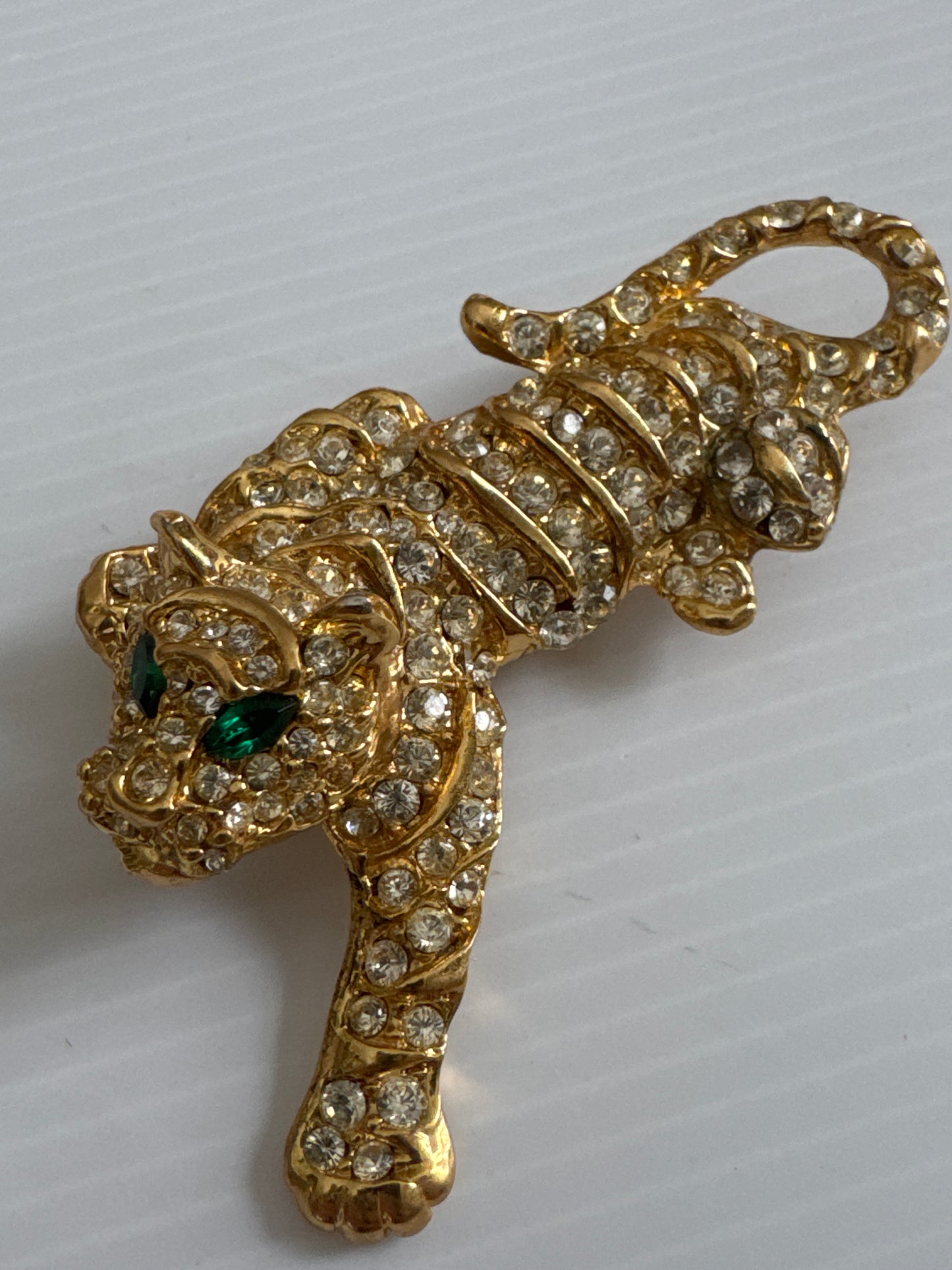 1980s gold tone rhinestone cheetah brooch with green emerald eyes