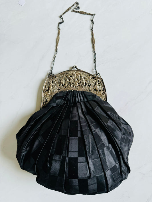 Early 1900's black pleated satin bag with pewter hardware depicting a scene. Lining is gorgeous w original beveled fabric covered purse mirror and coin purse