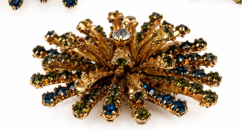 1960s multi layered starburst brooch with green blue and clear rhinestones on both sides of the starburst. Rare piece.