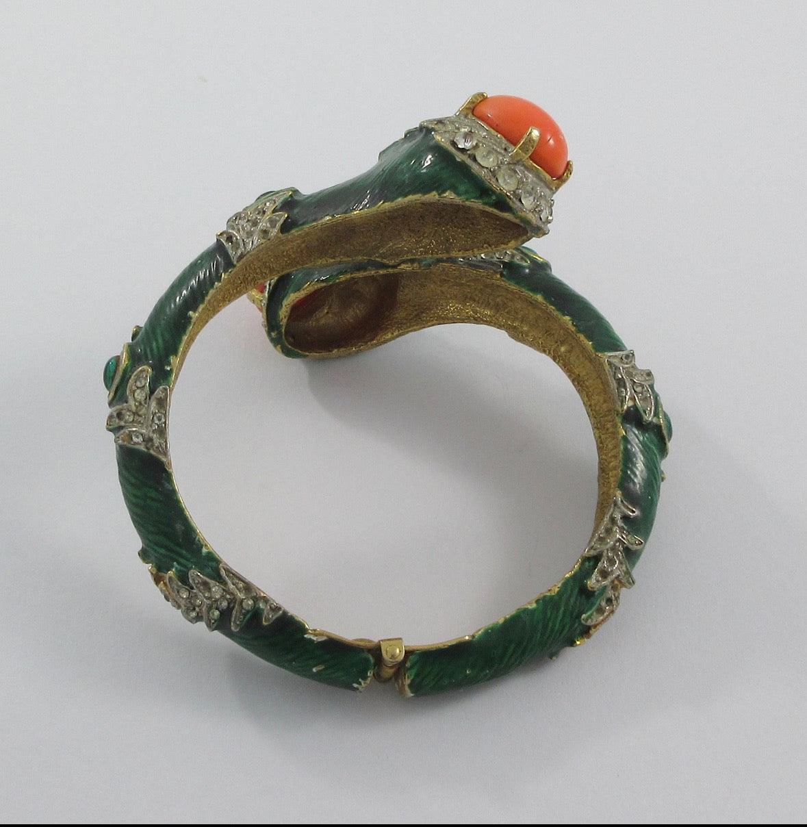 Unsigned Gold tone clamper bracelet with green enamel, rhinestone, faux coral cabochons and green cabochons attributed to Kenneth J Lane mid 1960s