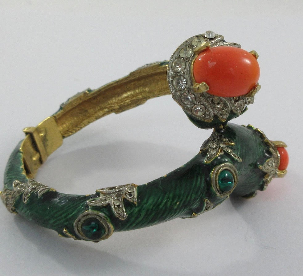 Unsigned Gold tone clamper bracelet with green enamel, rhinestone, faux coral cabochons and green cabochons attributed to Kenneth J Lane mid 1960s