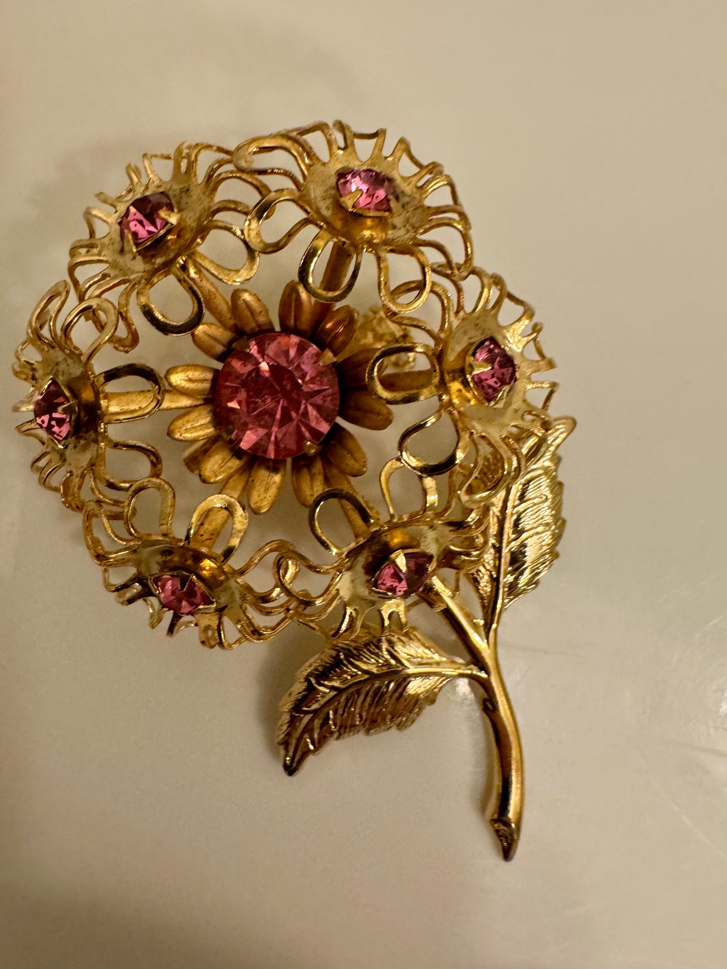 Charming filagree gold tone with pink rhinestone flower brooch