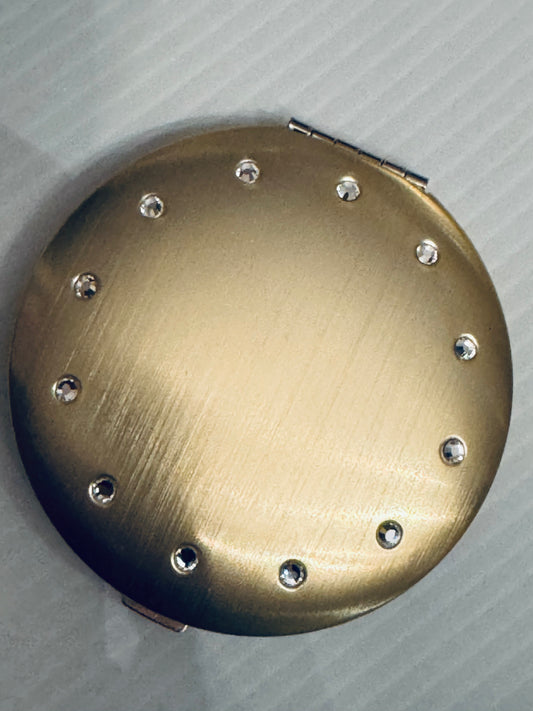 Vintage 2003 never used brushed gold Avon mirror compact with rhinestones. Comes with original box.