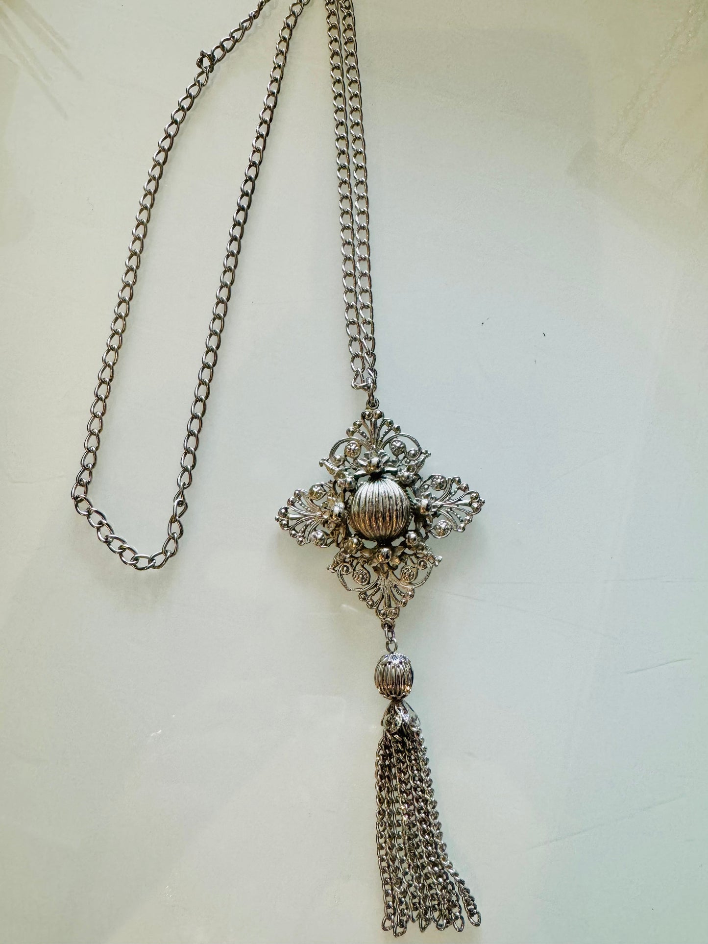 Silver tone pendant with tassel