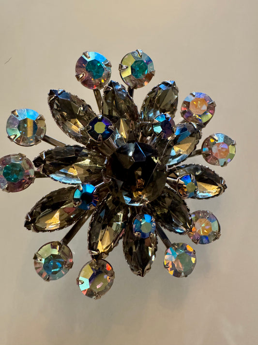 Stunning silver tone starburst brooch with reflective colorful rhinestones