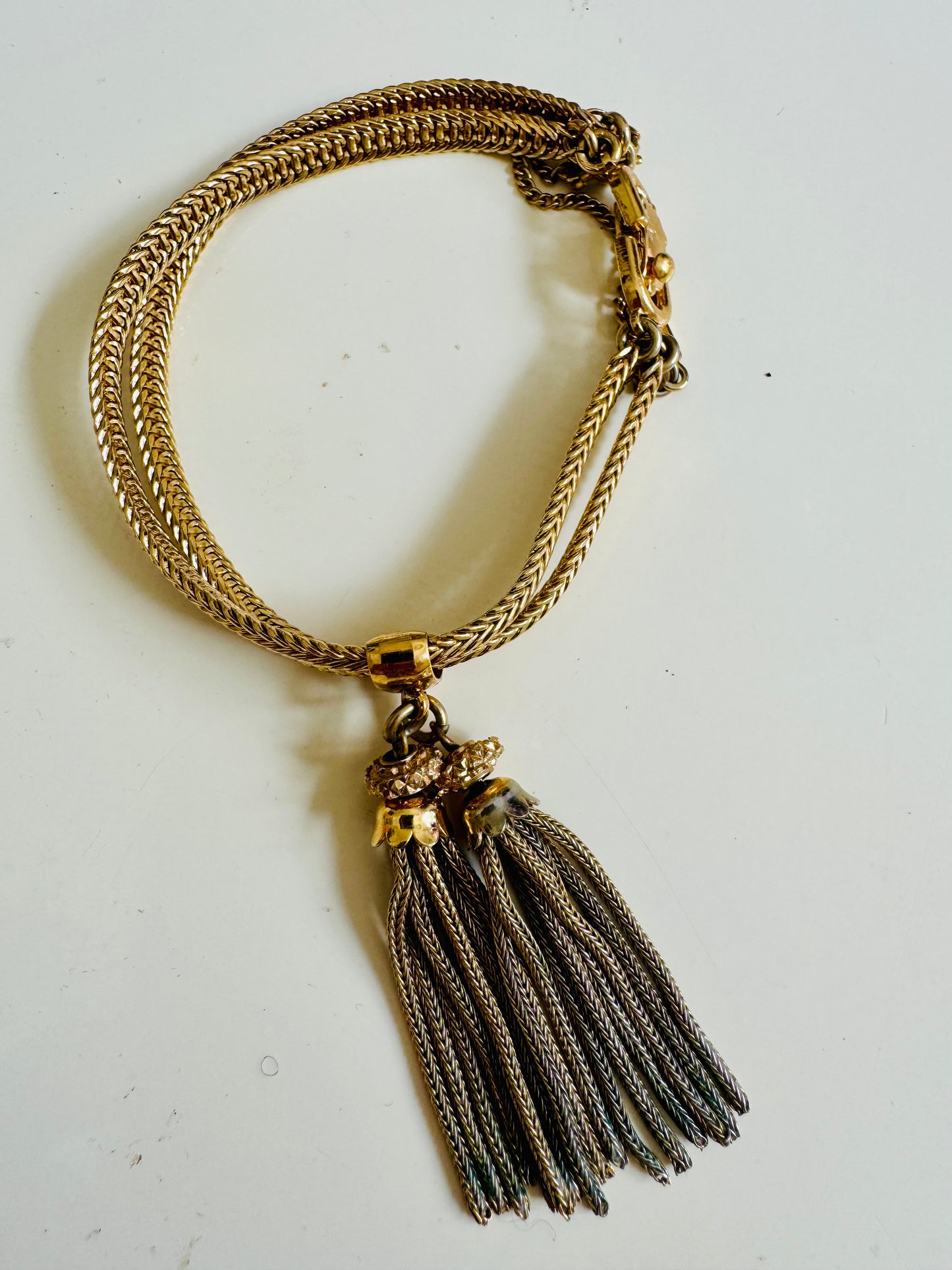 Vintage gold tone Monet bracelet with tassel and safety latch
