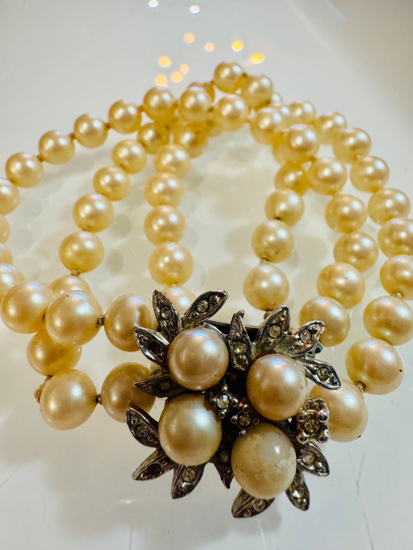 Stunning triple strand pearl bracelet with rhinestone closure