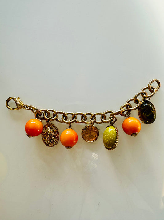 Charming 1950s charm bracelet. Gold tone with orange, gold and green charms