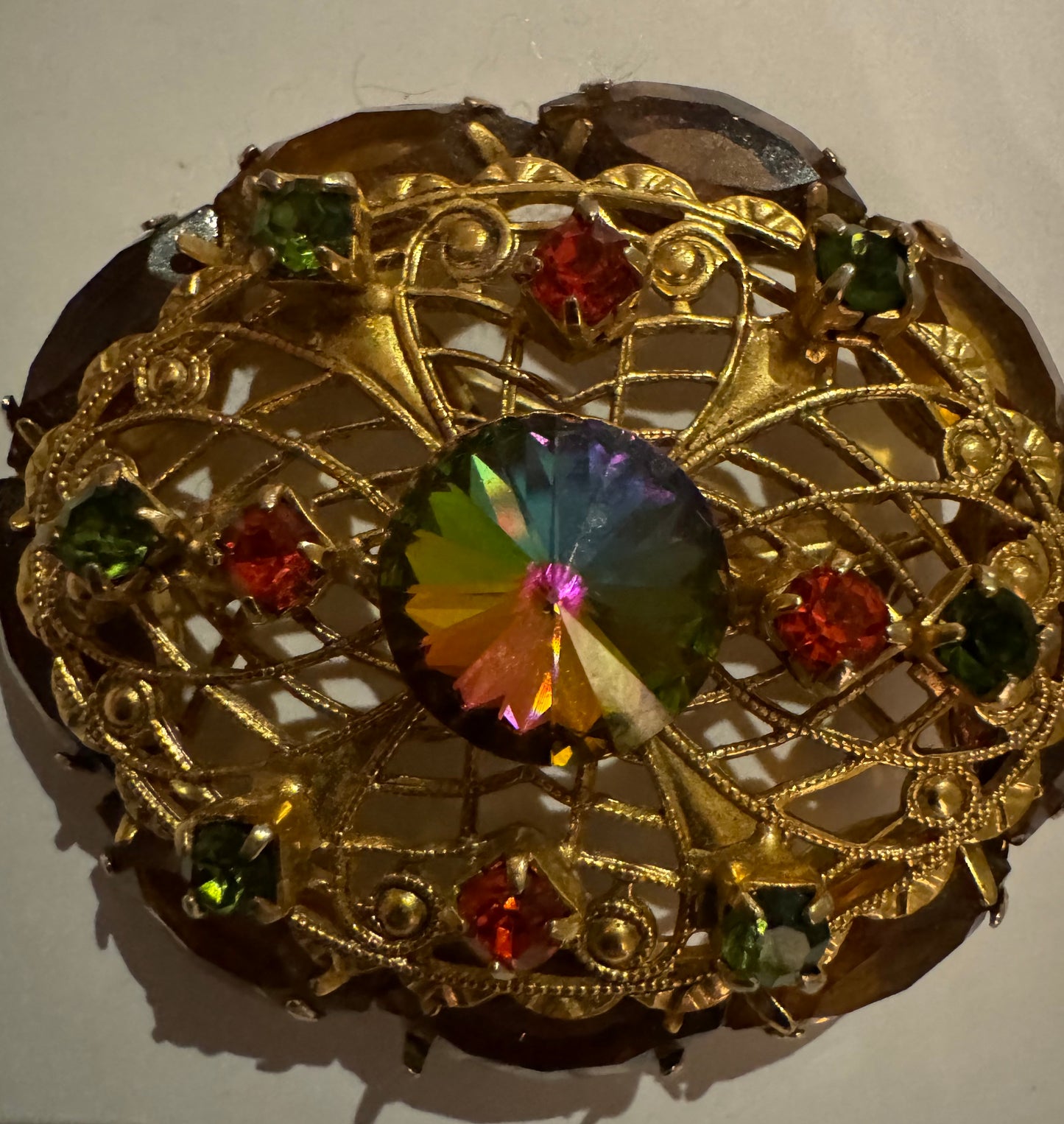 1950s Rivoli watermelon stone and filigree gold tone brooch. Note how center stone changes color in the light