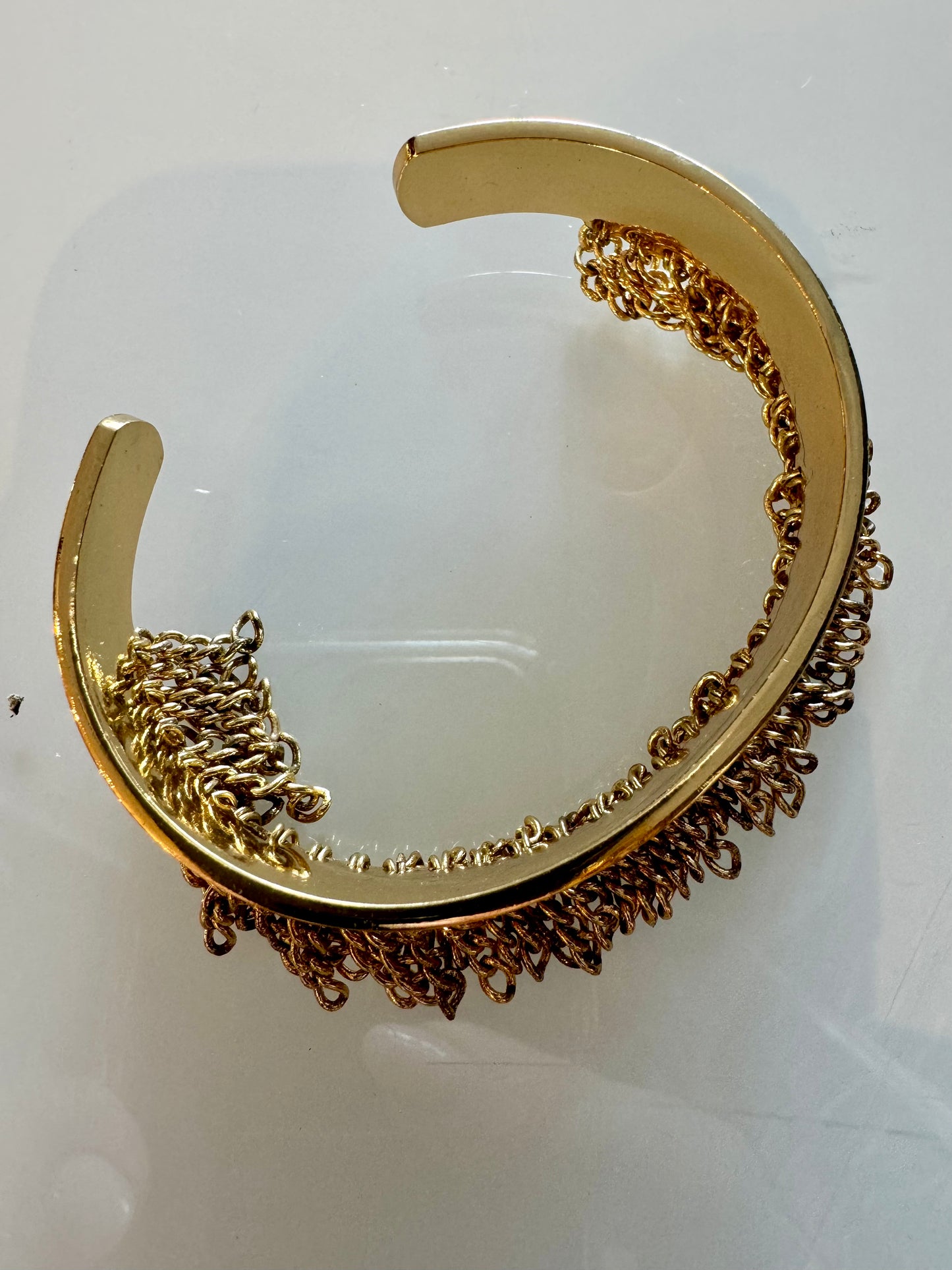 Gold tone adjustable bracelet with gold fringe detail