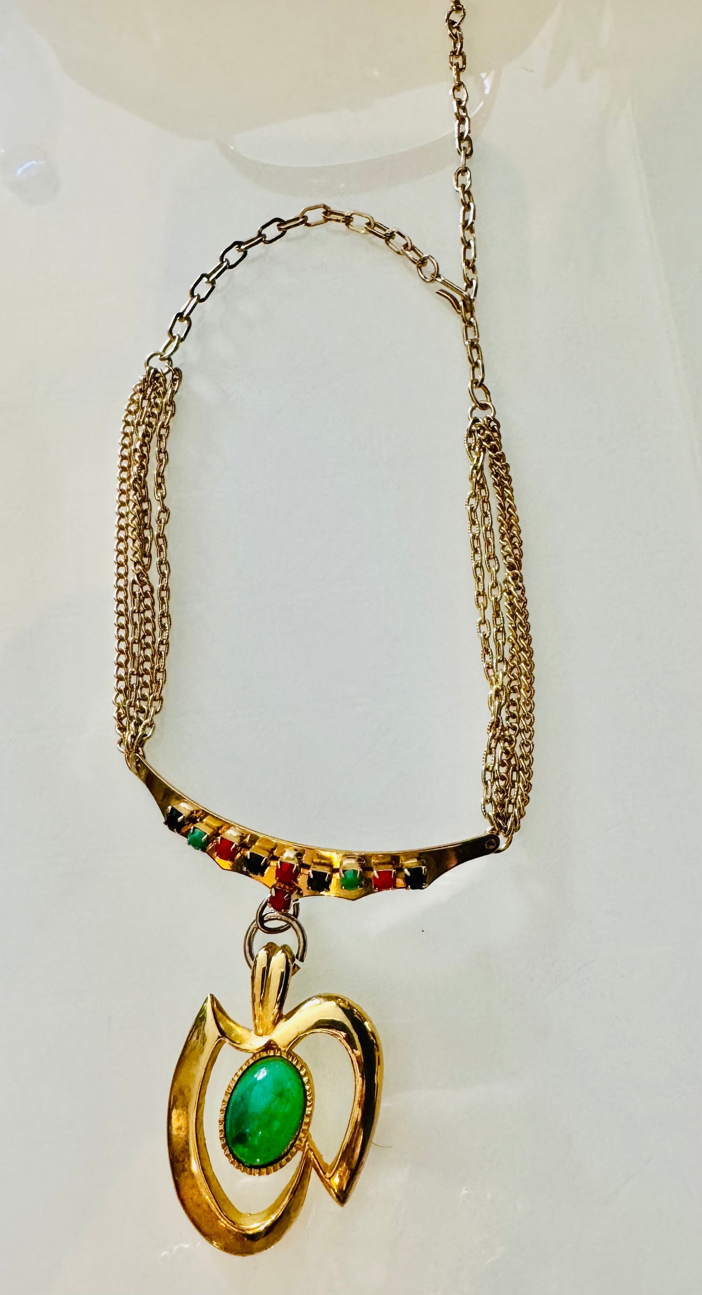 1960s gold tone necklace with green pendant and black, red and green rhinestones