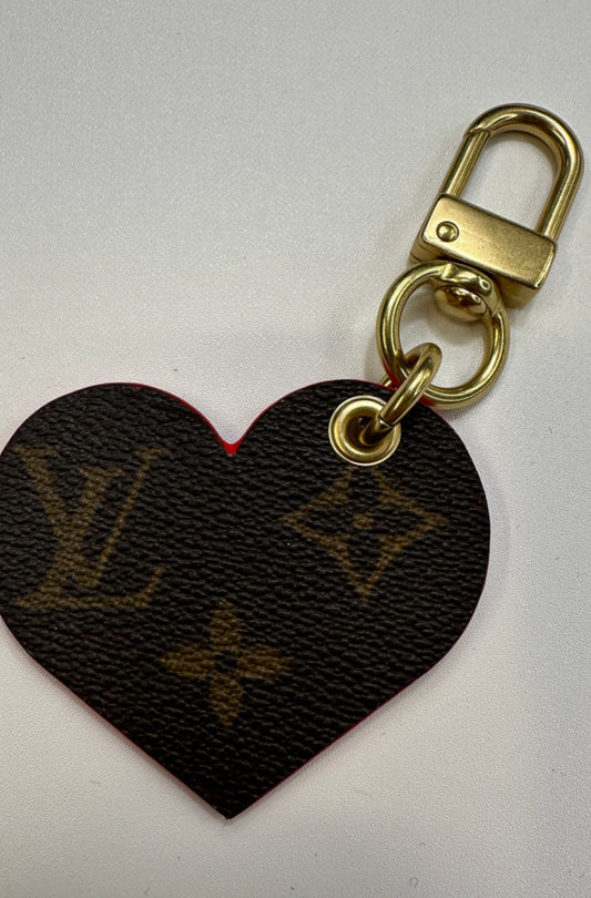 Upcycled authentic Louis Vuitton made into heart shaped bag charm. Choose black or red backing. Brass hardware.