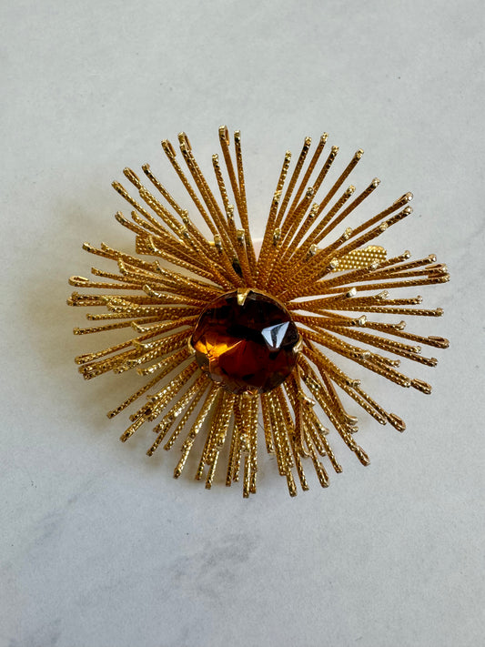 Prickly gold tone flower brooch with amber center stone
