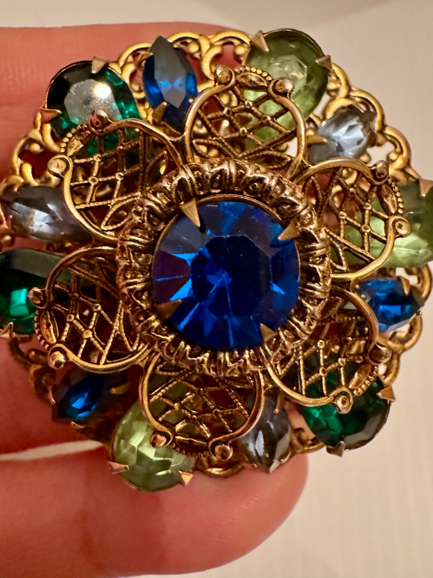 Beautiful 1950s gold tone filigree green and blue rhinestone round brooch