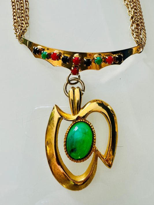 1960s gold tone necklace with green pendant and black, red and green rhinestones