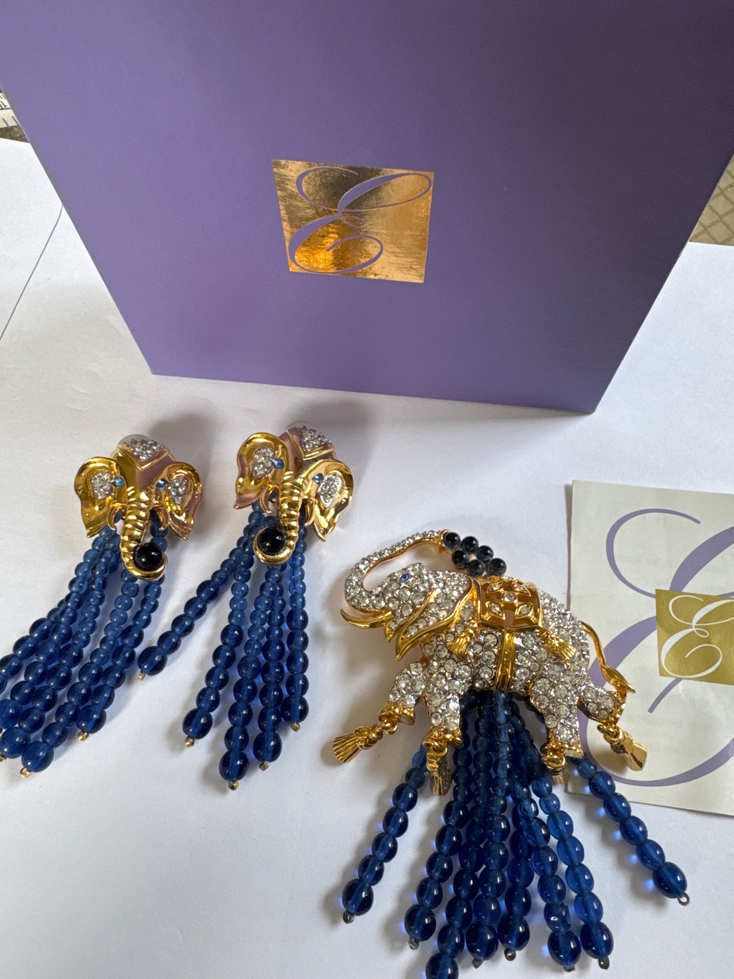 This original Avon set—designed in collaboration with Elizabeth Taylor—features jeweled elephants with cascading sapphire-toned drops.

Symbolizing strength, luck, and glamour… exactly the way Liz wore her jewels.

Complete with the original presentation