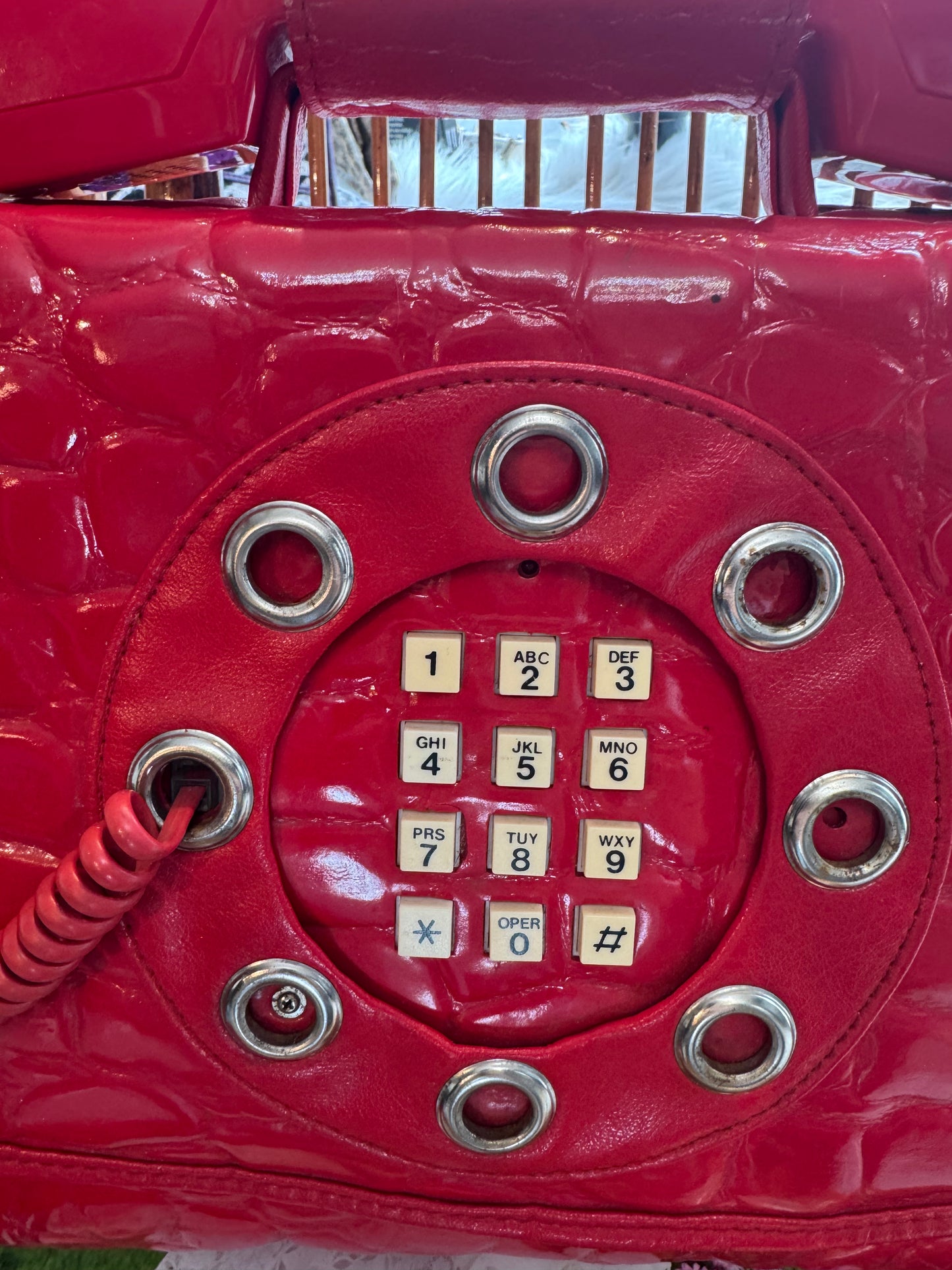 Vintage 1970s working (landline) red patent telephone handbag with top handle and crossbody strap.