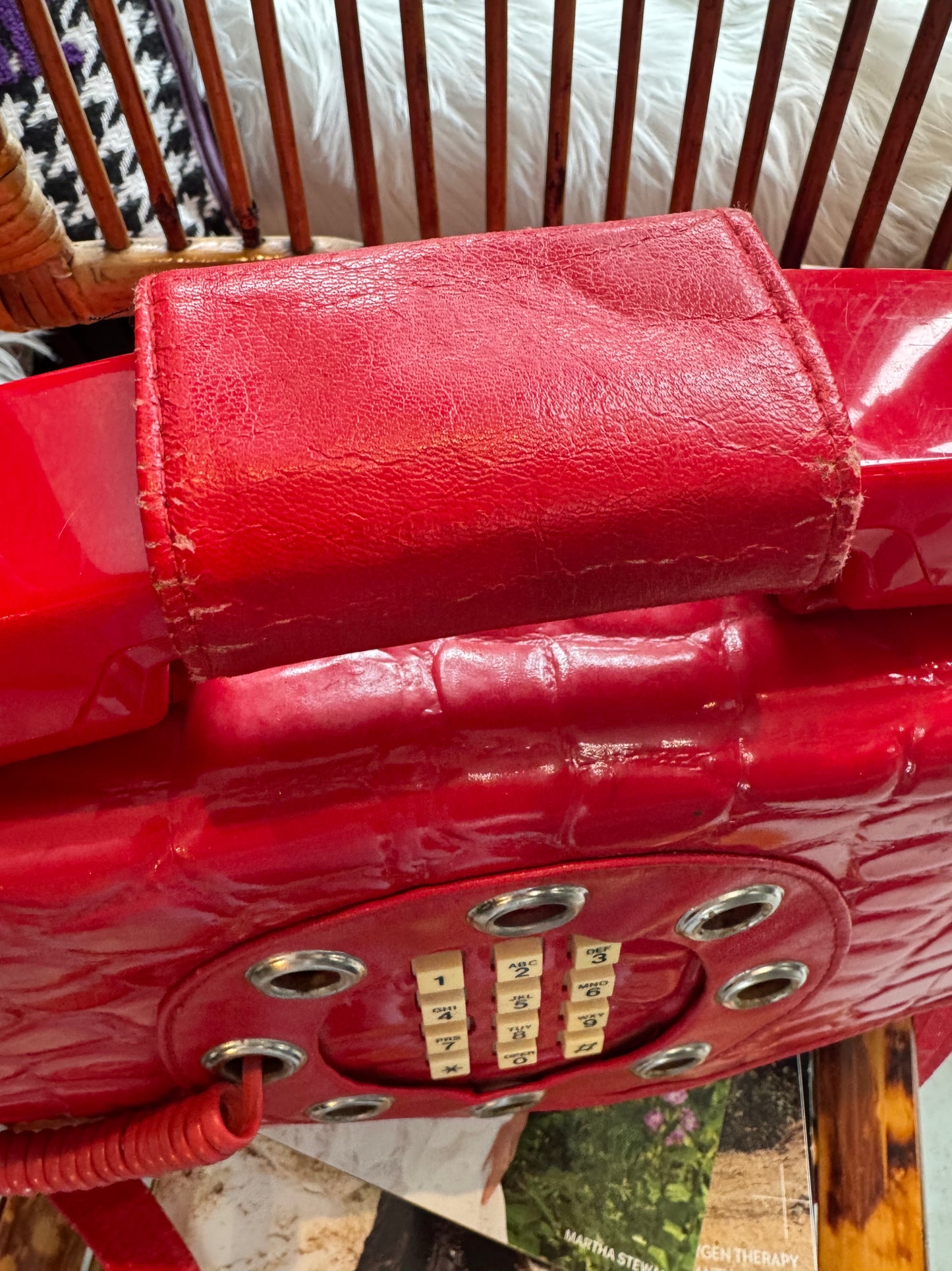 Vintage 1970s working (landline) red patent telephone handbag with top handle and crossbody strap.