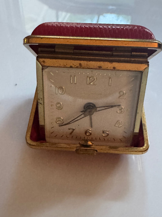 Vintage travel clock with red leather and gold edging. Wear on edges. Great display decor !