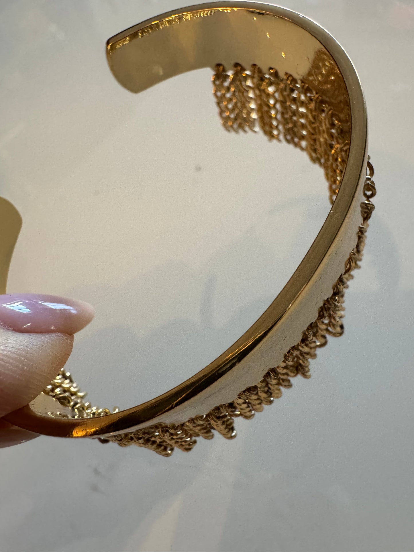 Gold tone adjustable bracelet with gold fringe detail