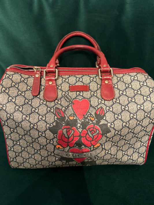 Pre-loved Gucci Boston Joy Tattoo Heart canvas with red leather top handle handbag. Comes with dust bag. Interior needs a little cleaning.