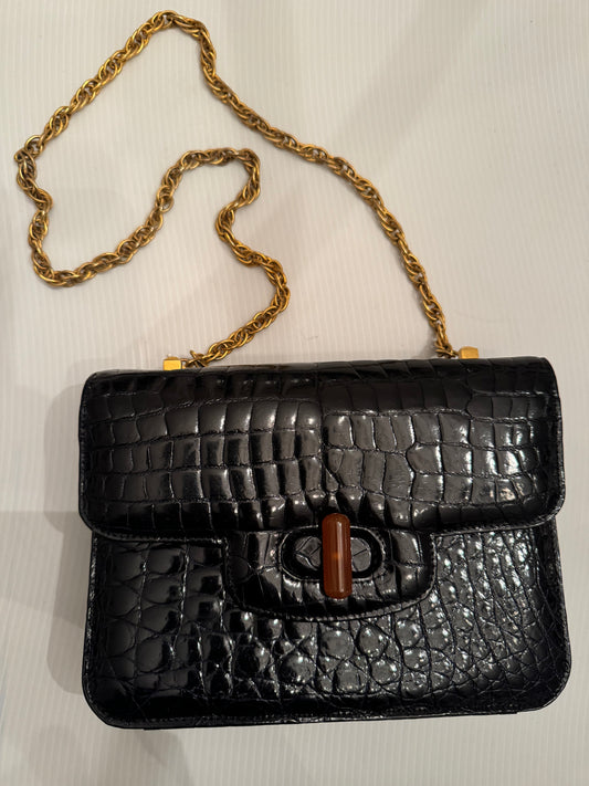 Elegant 1950s black crocodile shoulder bag with gold tone chain with bakelite closure.