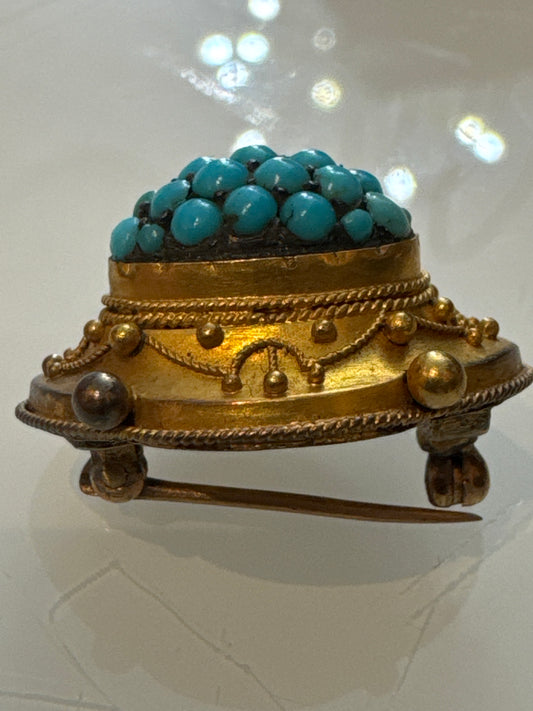 Mid-century Etruscan revival brooch featuring a domed cluster of turquoise cabochons set in richly detailed gold-tone metal with rope and granulation motifs. European made, circa 1950s.