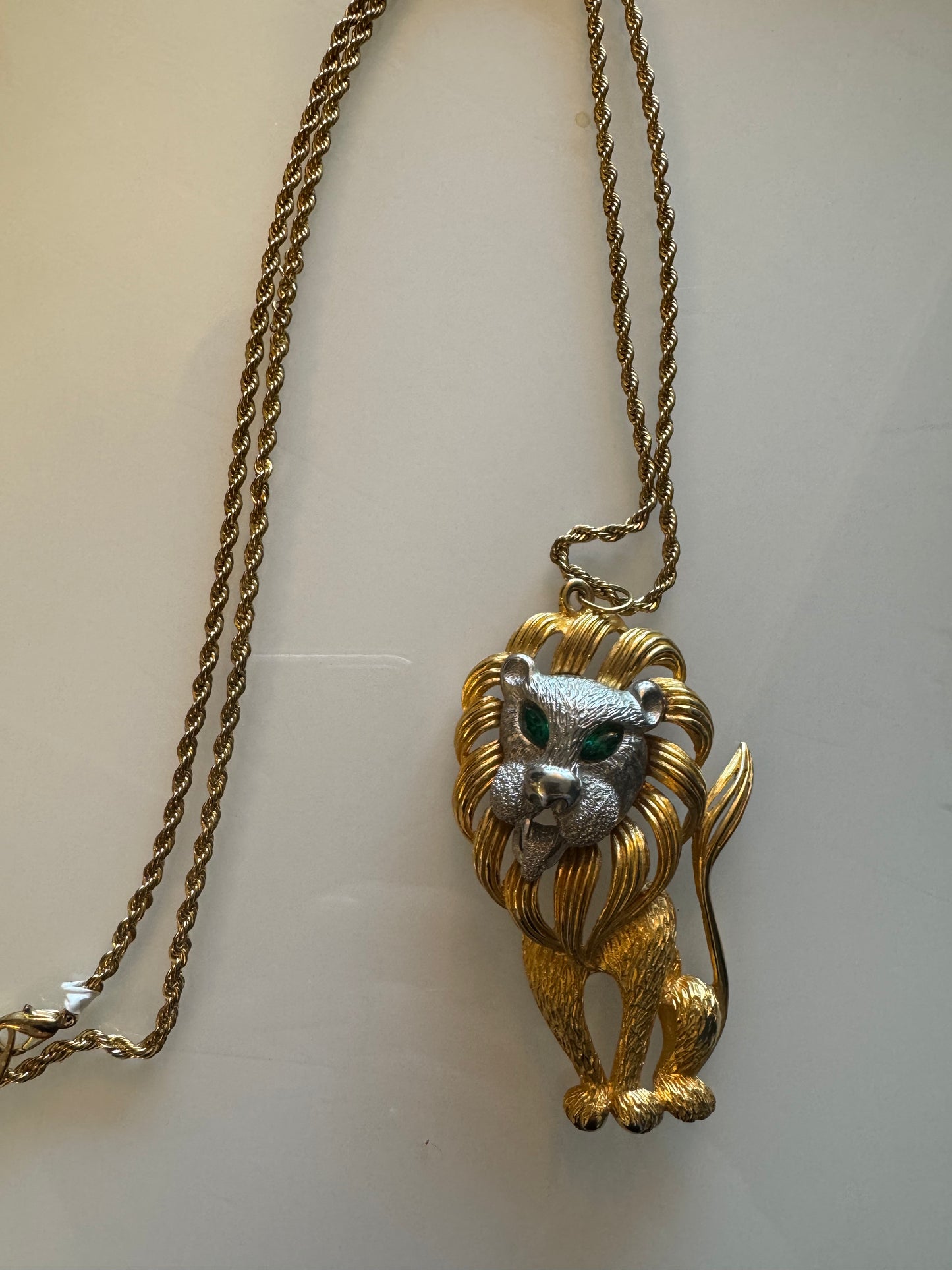 Goldtone Lion pendant with green rhinestone eyes and silver face