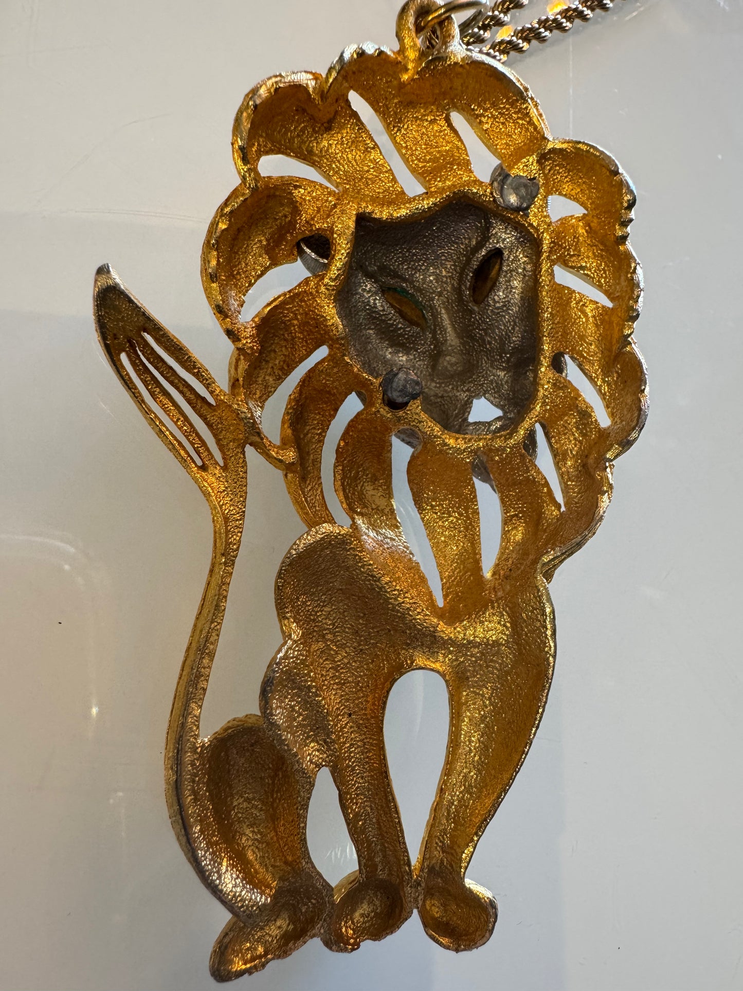 Goldtone Lion pendant with green rhinestone eyes and silver face