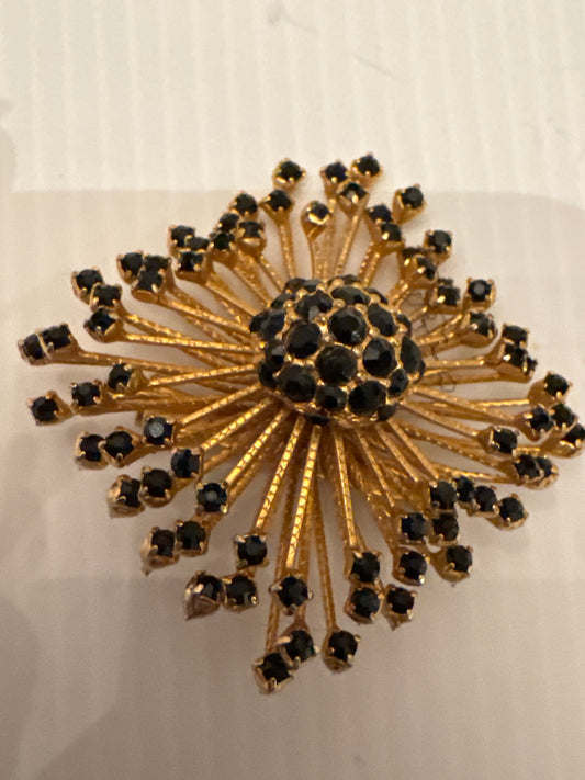 Jet black starburst spoke signed WARNER brooch